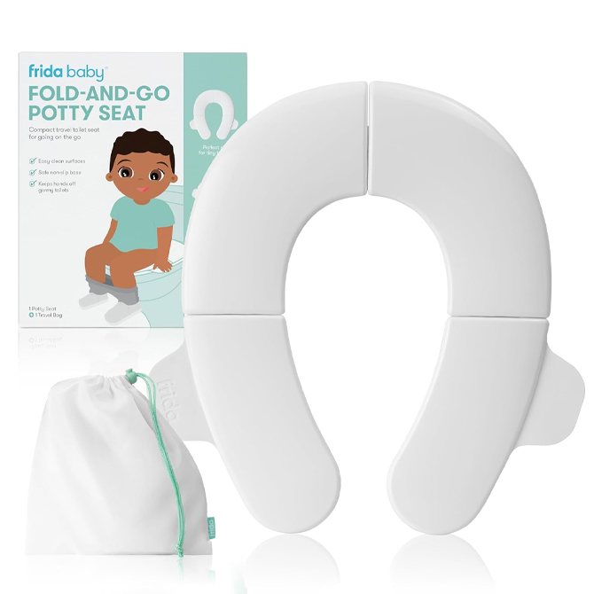 A white potty seat is in front of a box and a fabric bag.